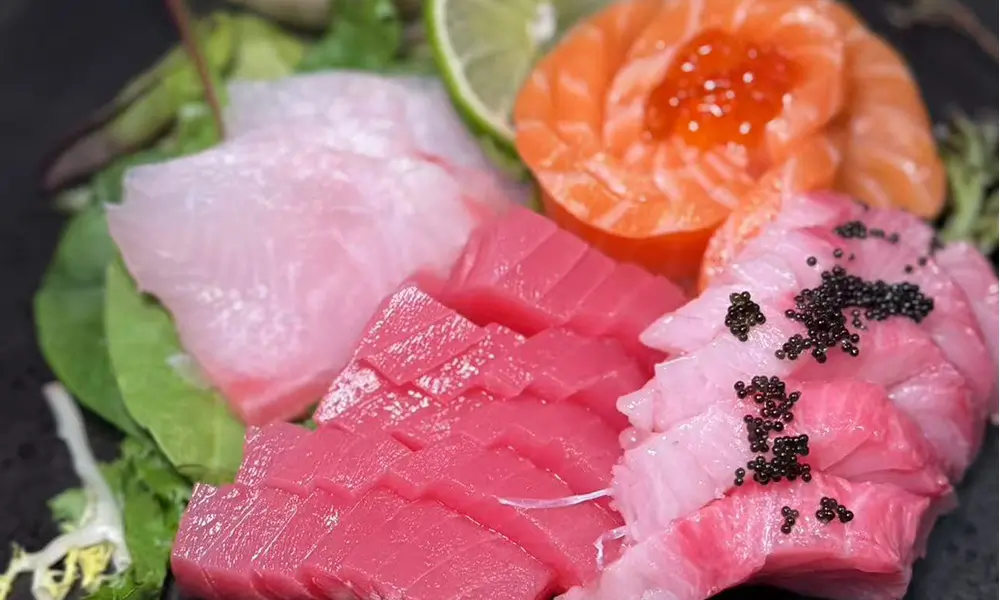 Sushi & Noodles-Japanese-Restaurant-Assorted-Sashimi-Platter-Brooklyn Fresh assorted sashimi with lime and greens at Sushi & Noodles a Japanese Restaurant in Brooklyn