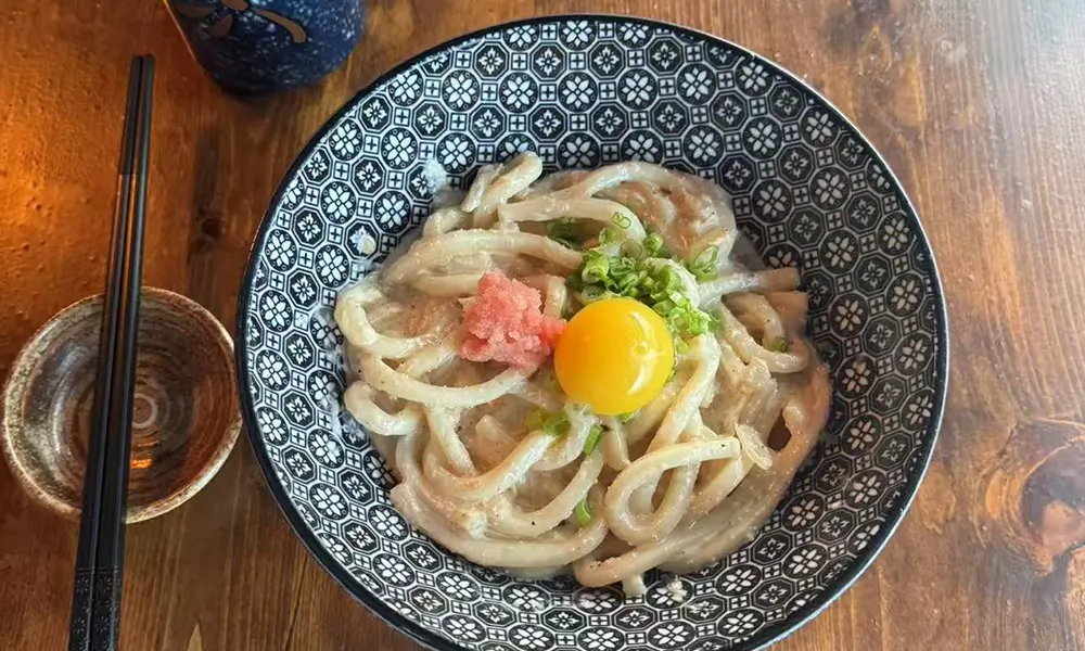 Creamy udon noodles with mentaiko and egg yolk at Sushi & Noodles a Japanese Restaurant in Brooklyn