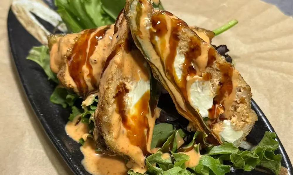 Fried jalapeño with cheese and drizzled sauce over greens at Sushi & Noodles a Japanese Restaurant in Brooklyn